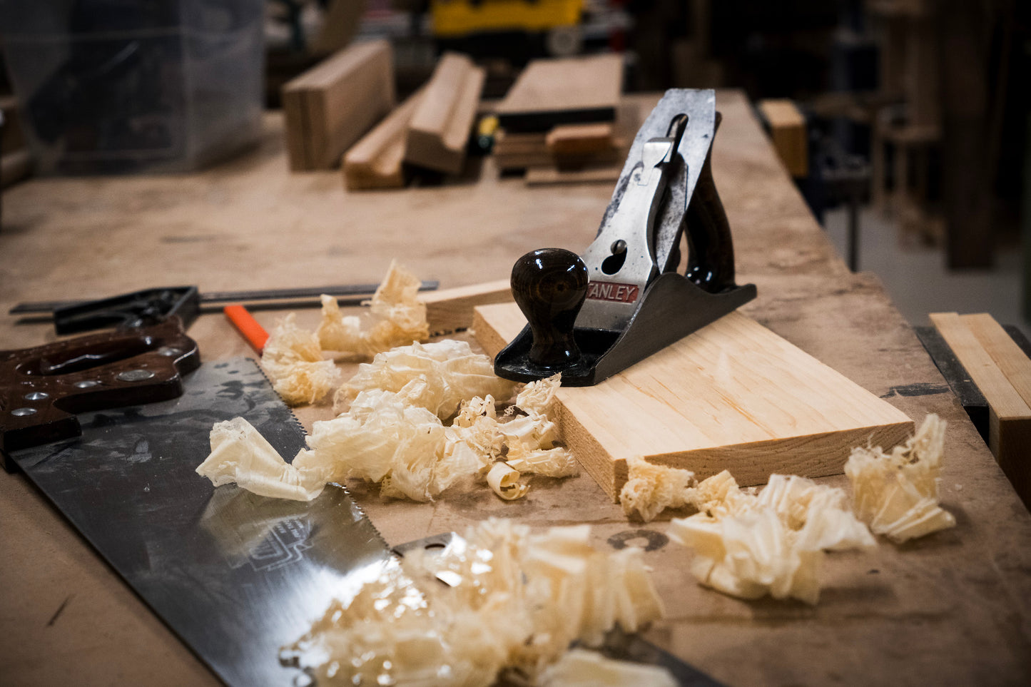 a wooden hand plane with a wood saw and wood shavings